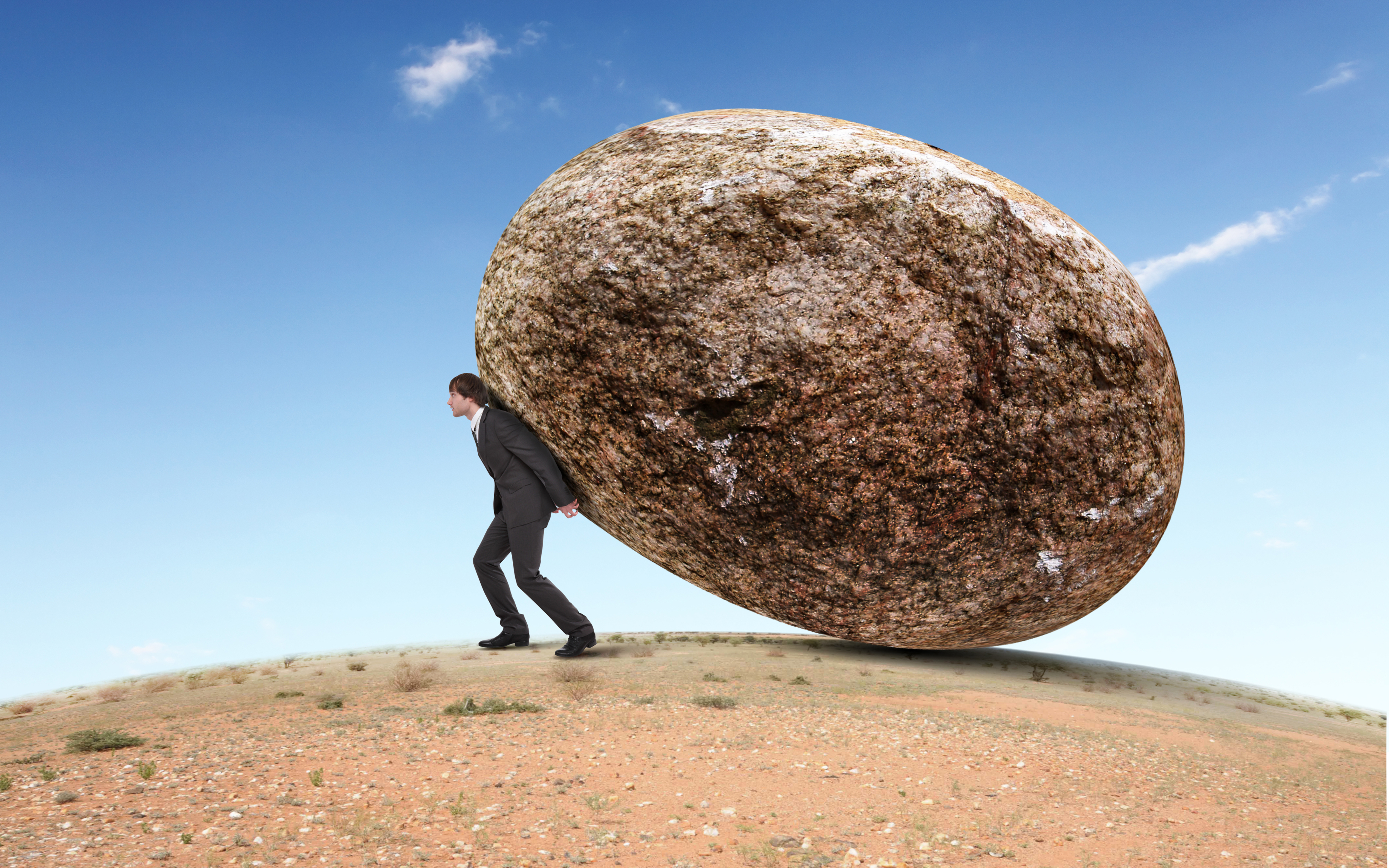 Человек держит тяжелый груз. Тяжелый камень. Человек камень. Человек и огромный камень. Огромный булыжник и человек.